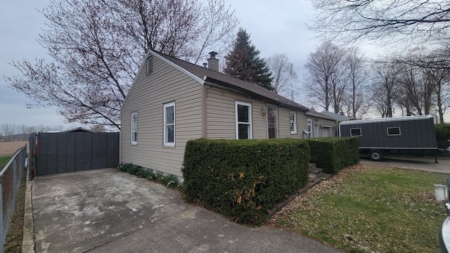 view of side of home with fence and a chimney