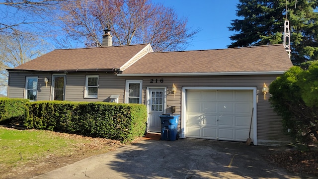 single story home featuring driveway, roof with shingles, an attached garage, and a chimney