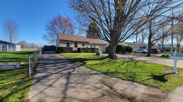 ranch-style house featuring driveway, fence, a front yard, and an attached garage