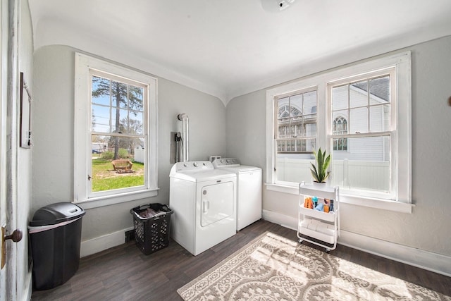 clothes washing area featuring separate washer and dryer, laundry area, dark wood-style floors, and baseboards