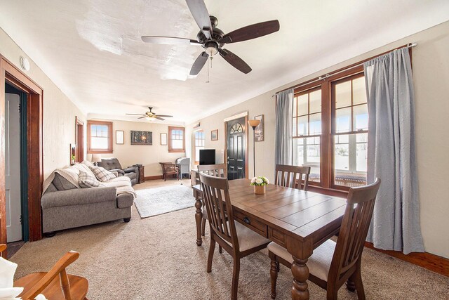 dining space featuring light carpet and a ceiling fan
