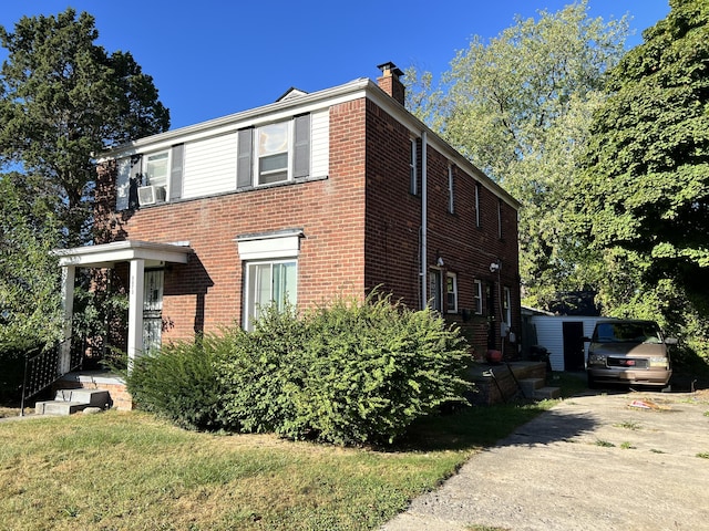view of side of property with a chimney, cooling unit, and brick siding