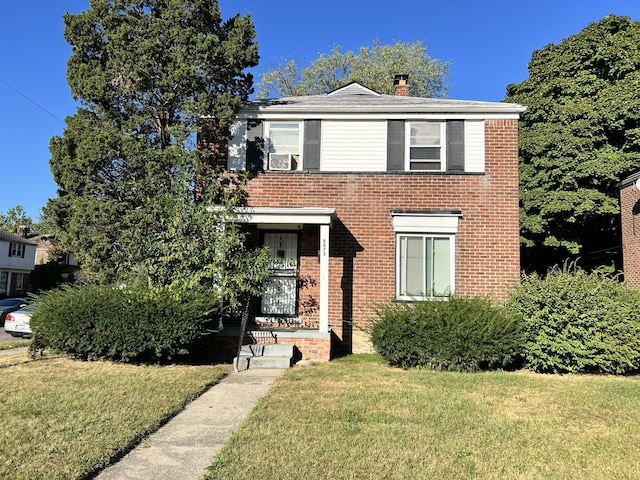 view of front facade with a front yard, a chimney, and brick siding
