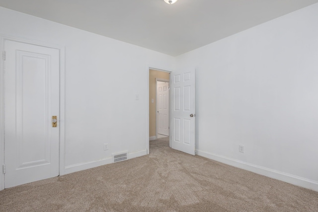 unfurnished room featuring visible vents, baseboards, and light carpet