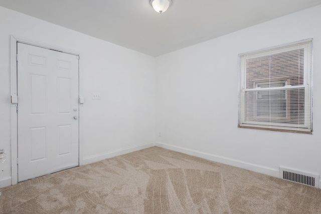 unfurnished room with carpet flooring, visible vents, and baseboards