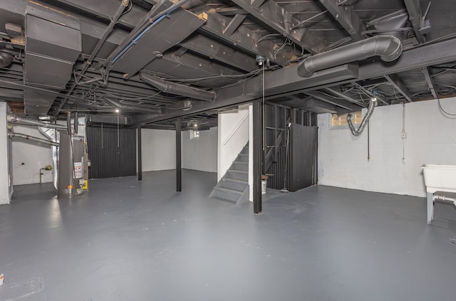 basement featuring water heater and stairs
