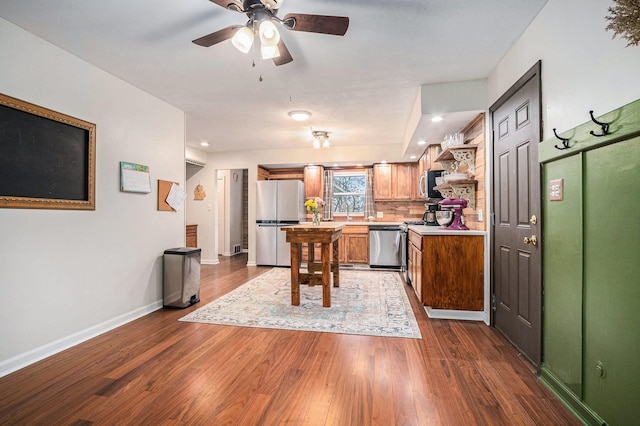 kitchen featuring recessed lighting, stainless steel appliances, light countertops, dark wood-style flooring, and baseboards