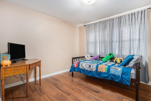 bedroom featuring baseboards and wood finished floors