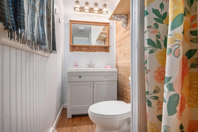 full bathroom with a shower with curtain, vanity, toilet, baseboards, and wood finished floors