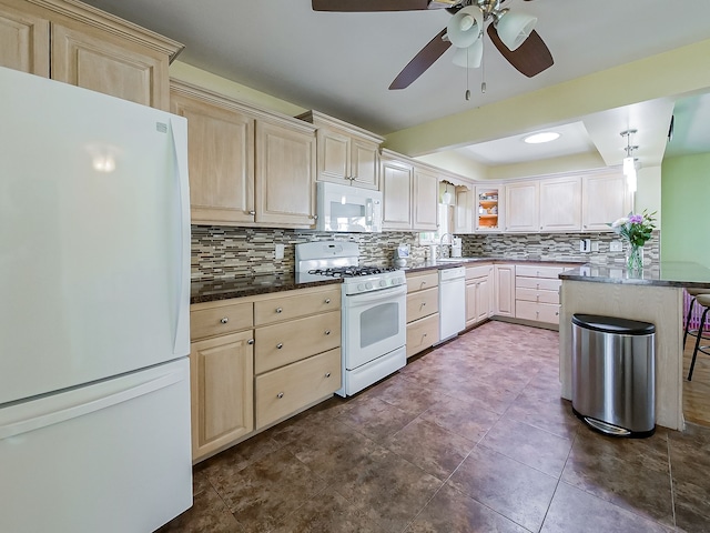kitchen featuring ceiling fan, backsplash, a sink, a tray ceiling, and white appliances