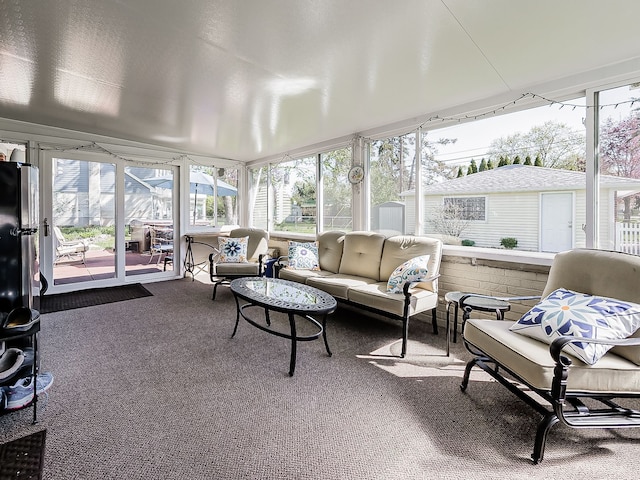 sunroom featuring a healthy amount of sunlight, outdoor lounge area, and carpet flooring