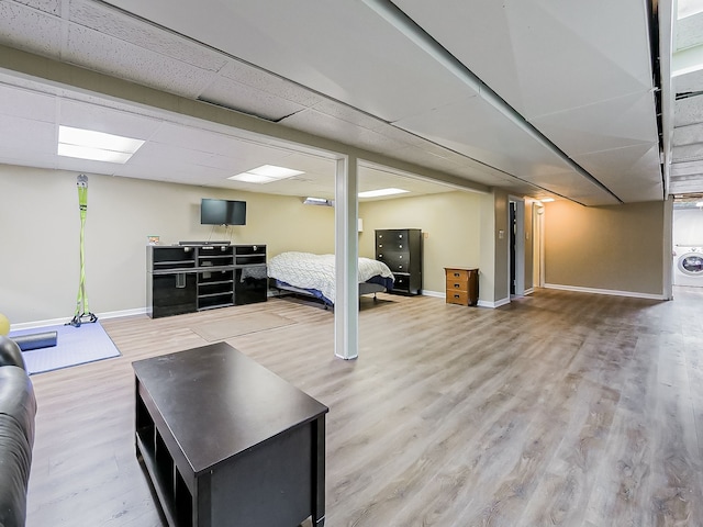 finished basement featuring washer / dryer, baseboards, and wood finished floors