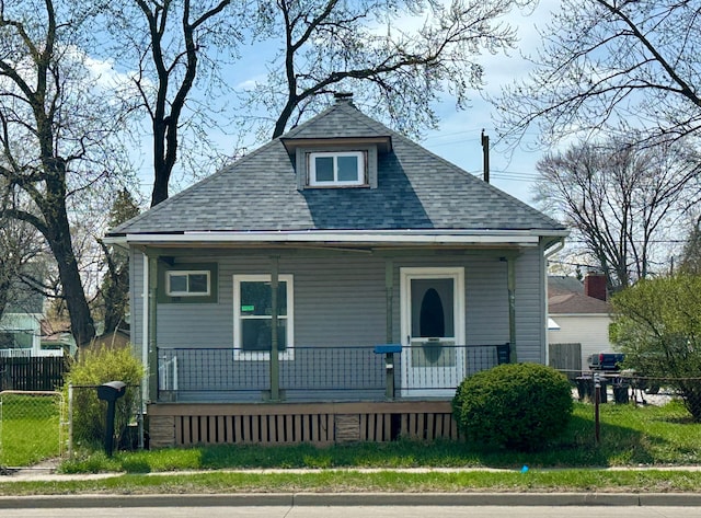 bungalow-style home with fence, a porch, and a shingled roof