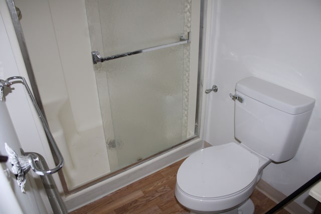 33185 Swallow Dr, Rockwood, MI 48173 - full bathroom with a stall shower, toilet, and wood finished floors