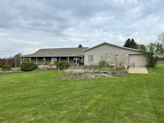 back of property with a lawn, an attached garage, and covered porch
