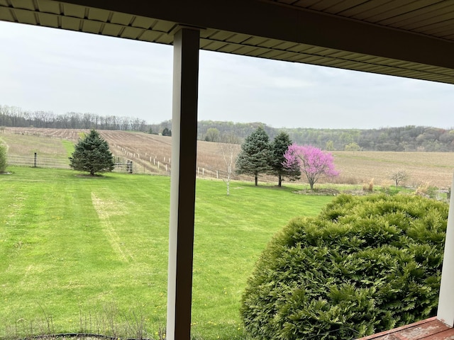 view of yard with fence and a rural view