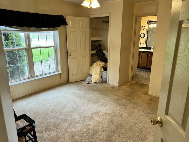 unfurnished bedroom with carpet, ensuite bathroom, a closet, and baseboards