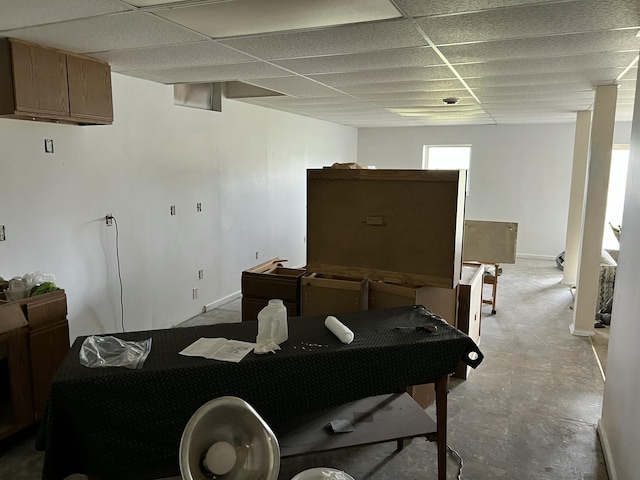 dining space with a paneled ceiling and concrete flooring