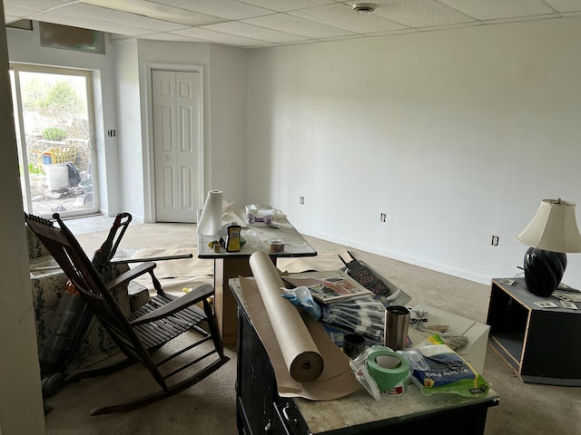 interior space featuring a paneled ceiling and light carpet