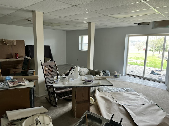 interior space featuring a paneled ceiling, baseboards, and carpet floors