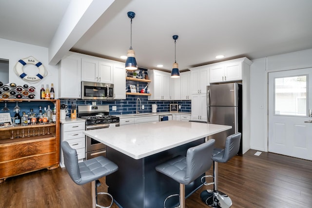 6950 Shore Dr, Coloma, MI 49038 - kitchen with dark wood-style floors, a sink, a kitchen breakfast bar, open shelves, and appliances with stainless steel finishes