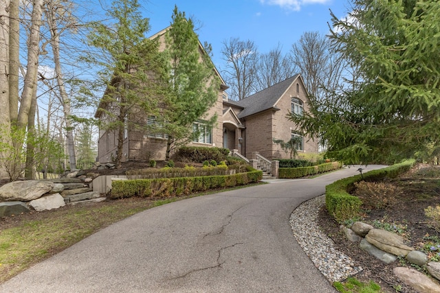view of side of property with aphalt driveway and brick siding