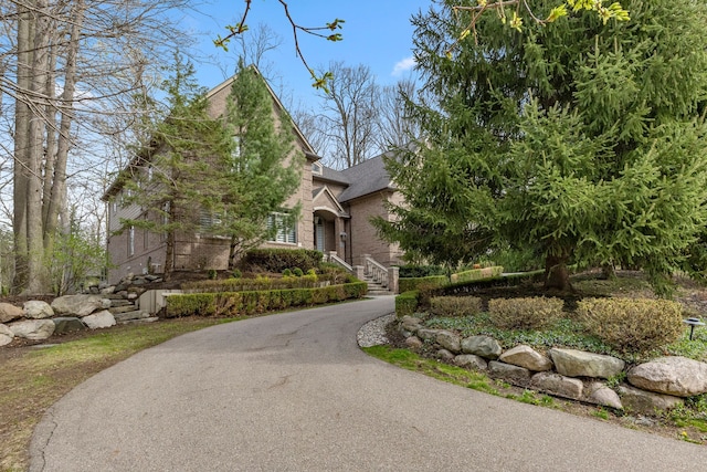 obstructed view of property with driveway and brick siding