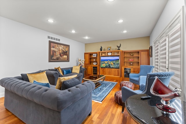 living room featuring wood finished floors, recessed lighting, and visible vents