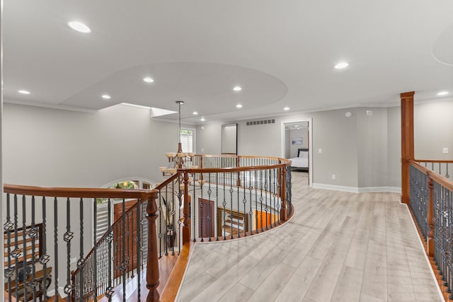 corridor with crown molding, recessed lighting, an upstairs landing, and light wood-type flooring
