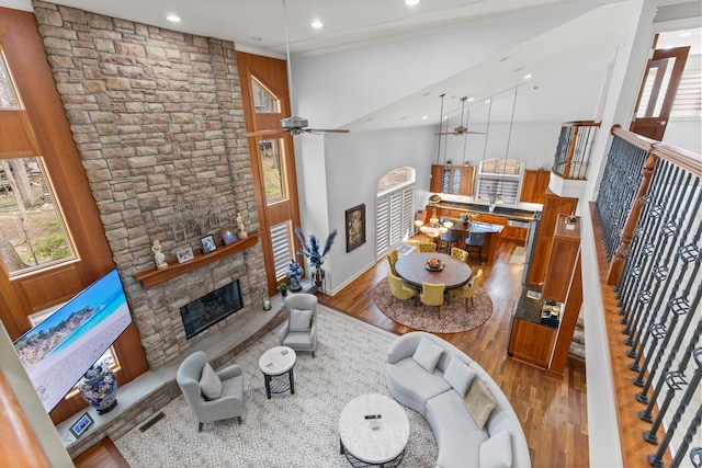 living room featuring a ceiling fan, a wealth of natural light, wood finished floors, and a fireplace
