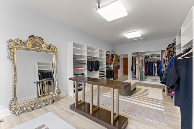 walk in closet with wood finished floors
