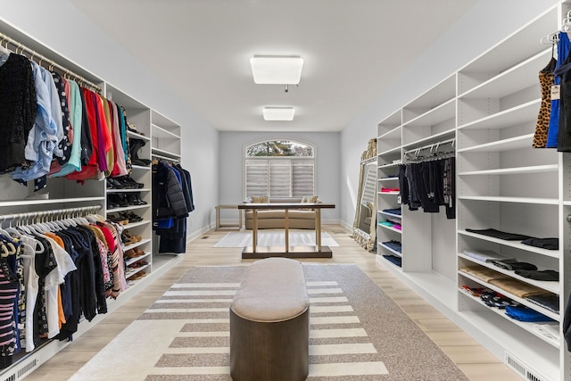 walk in closet with wood finished floors