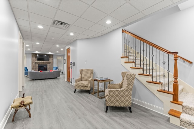 living area with wood finished floors, visible vents, stairs, and baseboards