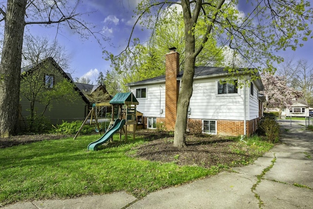 314 Hiawatha St, Ypsilanti, MI 48197 - rear view of house featuring a playground, a chimney, fence, a yard, and brick siding