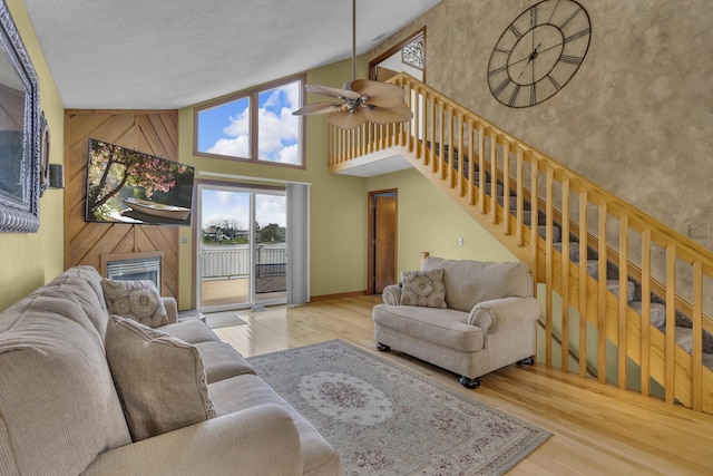 9015 Kingsley Dr, Onsted, MI 49265 - living area with stairs, high vaulted ceiling, a ceiling fan, and wood finished floors