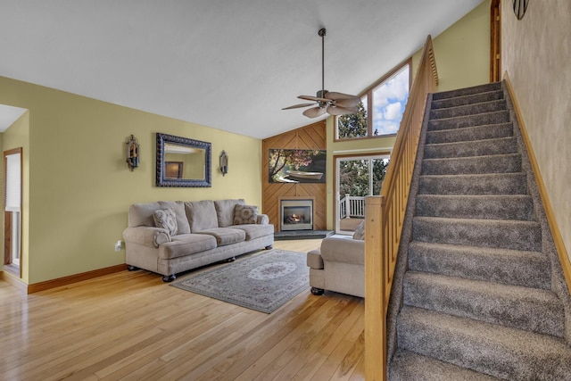9015 Kingsley Dr, Onsted, MI 49265 - living room featuring stairs, light wood-style floors, a glass covered fireplace, baseboards, and a ceiling fan
