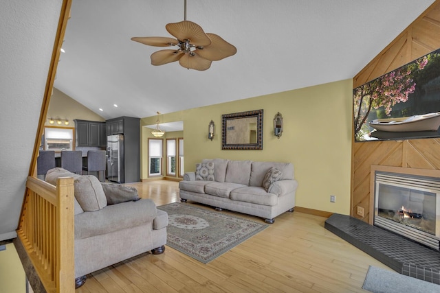 9015 Kingsley Dr, Onsted, MI 49265 - living room featuring a glass covered fireplace, ceiling fan, vaulted ceiling, and light wood-style floors