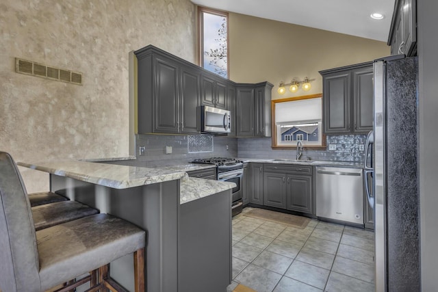 9015 Kingsley Dr, Onsted, MI 49265 - kitchen with a sink, appliances with stainless steel finishes, visible vents, a peninsula, and gray cabinets