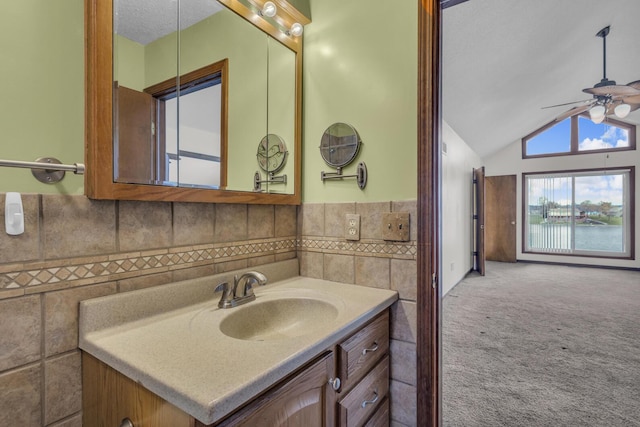 9015 Kingsley Dr, Onsted, MI 49265 - bathroom featuring tile walls, vaulted ceiling, a ceiling fan, and vanity