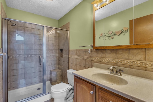 9015 Kingsley Dr, Onsted, MI 49265 - bathroom with tile walls, toilet, vanity, a stall shower, and a textured ceiling