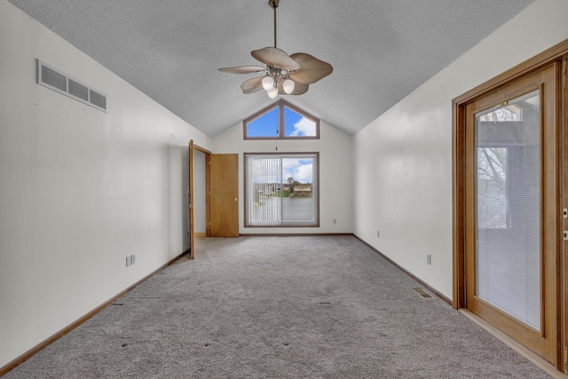 9015 Kingsley Dr, Onsted, MI 49265 - carpeted empty room featuring a textured ceiling, visible vents, ceiling fan, and vaulted ceiling