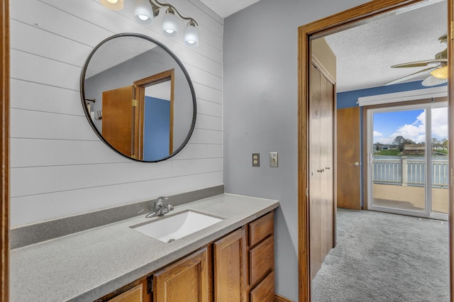 9015 Kingsley Dr, Onsted, MI 49265 - bathroom featuring wooden walls, a ceiling fan, a textured ceiling, and vanity