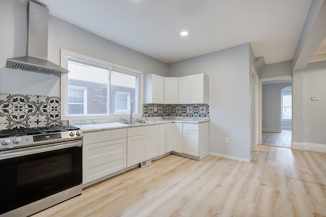 849 Chalmers St, Detroit, MI 48215 - kitchen with wall chimney range hood, decorative backsplash, light wood-style flooring, a sink, and gas range