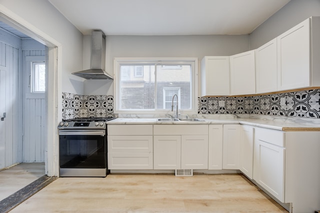 849 Chalmers St, Detroit, MI 48215 - kitchen featuring a sink, visible vents, light wood-style flooring, wall chimney range hood, and gas stove