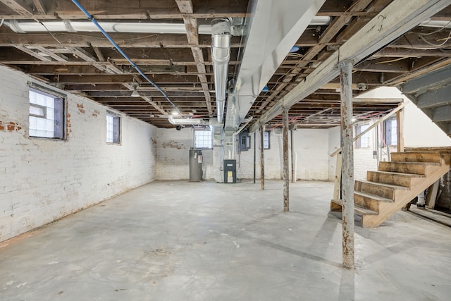 849 Chalmers St, Detroit, MI 48215 - below grade area featuring heating unit, electric water heater, and stairs