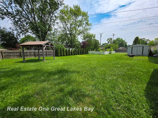 1520 Coolidge Ave, Saginaw, MI 48638 - fenced backyard featuring a gazebo and a storage unit