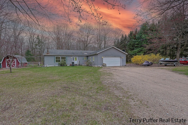 22 N Bossett Rd, Ravenna, MI 49451 - view of front of property featuring an outdoor structure, a yard, driveway, a storage unit, and an attached garage