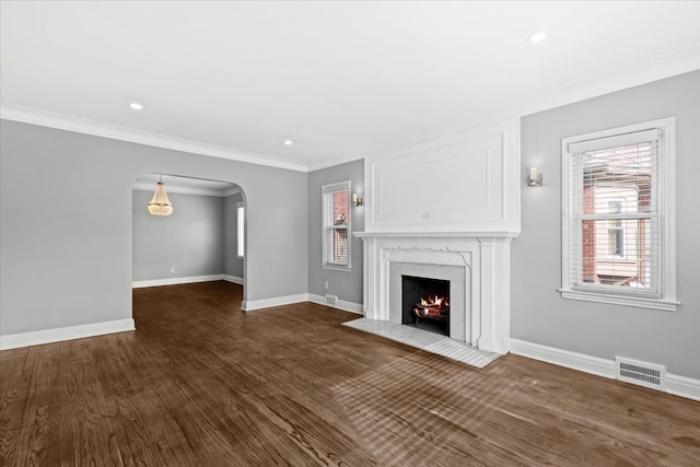 18603 Monica St, Detroit, MI 48221 - unfurnished living room featuring arched walkways, a fireplace, baseboards, visible vents, and dark wood-type flooring