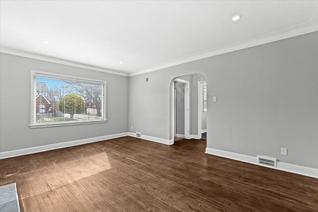 18603 Monica St, Detroit, MI 48221 - unfurnished room with dark wood finished floors, arched walkways, ornamental molding, baseboards, and visible vents