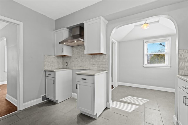 18603 Monica St, Detroit, MI 48221 - kitchen with arched walkways, backsplash, wall chimney exhaust hood, and light countertops